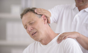 Un homme atteint d'ostéochondrose du cou à la réception d'un masseur manuel
